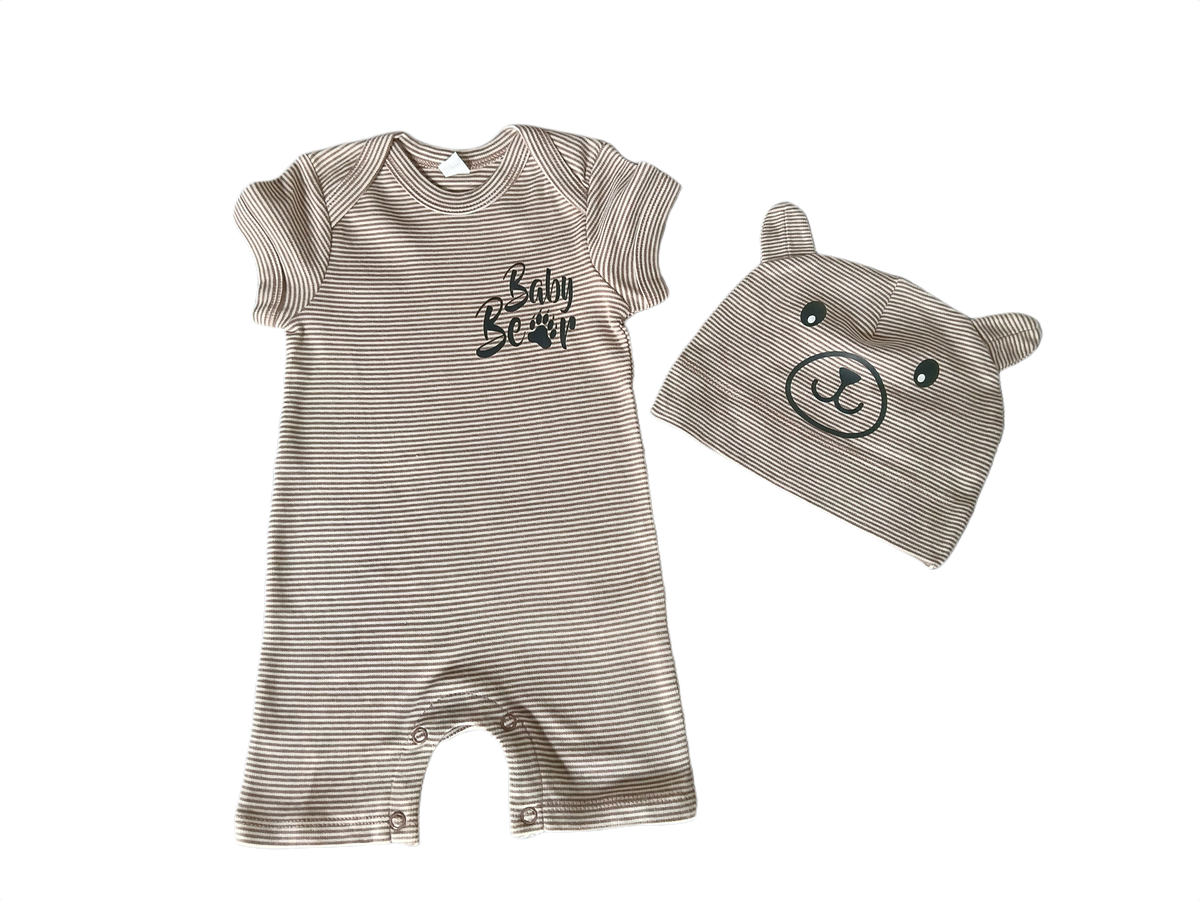 A baby clothing set featuring a short-sleeve ribbed romper and a matching bear-face hood, both in a light taupe-beige color with black details