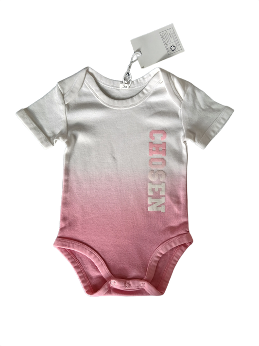 A short-sleeve baby bodysuit featuring a white-to-pink gradient, with the word 'CHOSEN' printed across the chest in pink letters. 